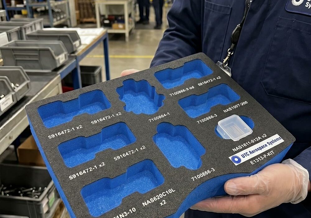 A person carrying an industrial foam tray in a factory
